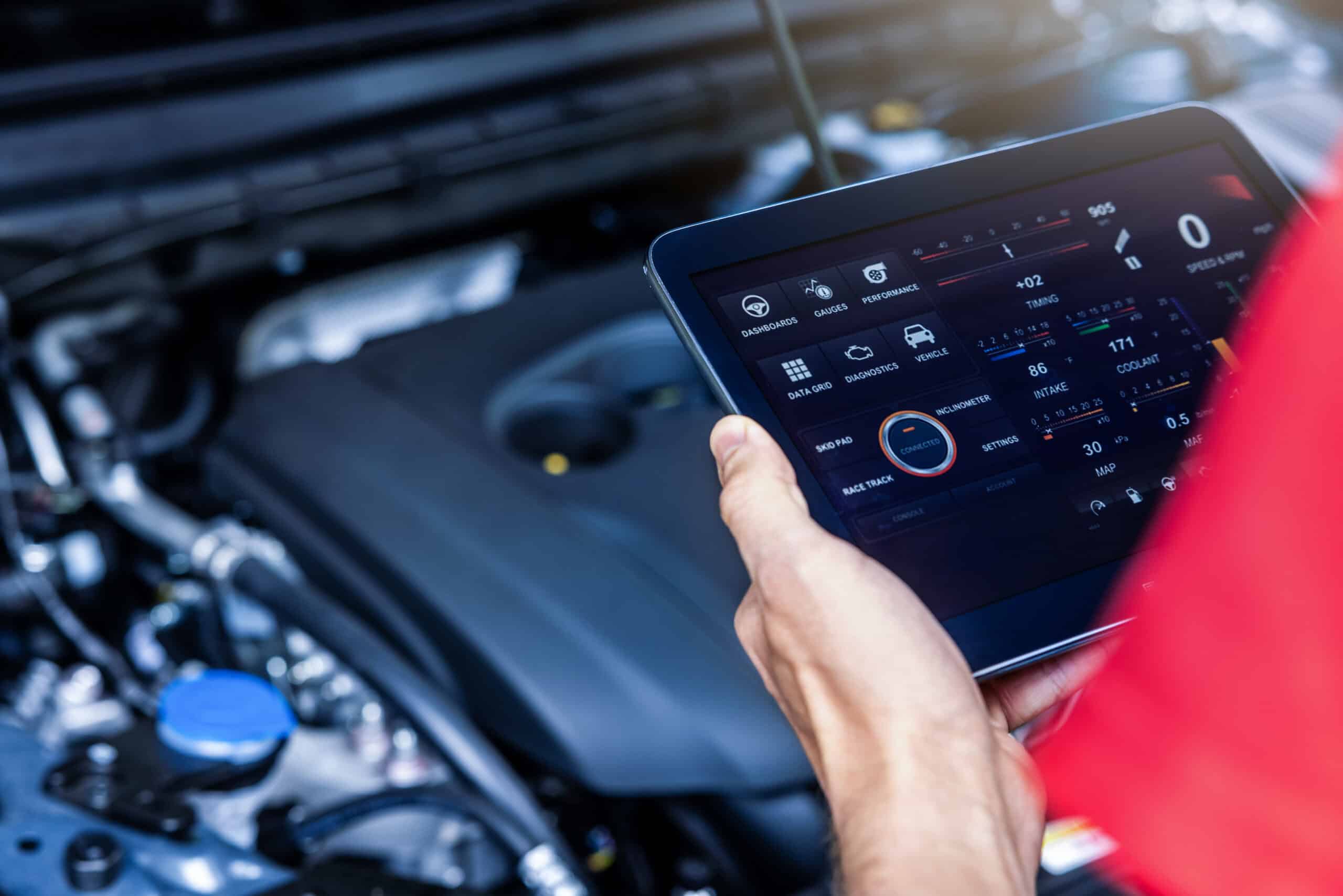 Person reviewing vehicle diagnostic readings on a tablet