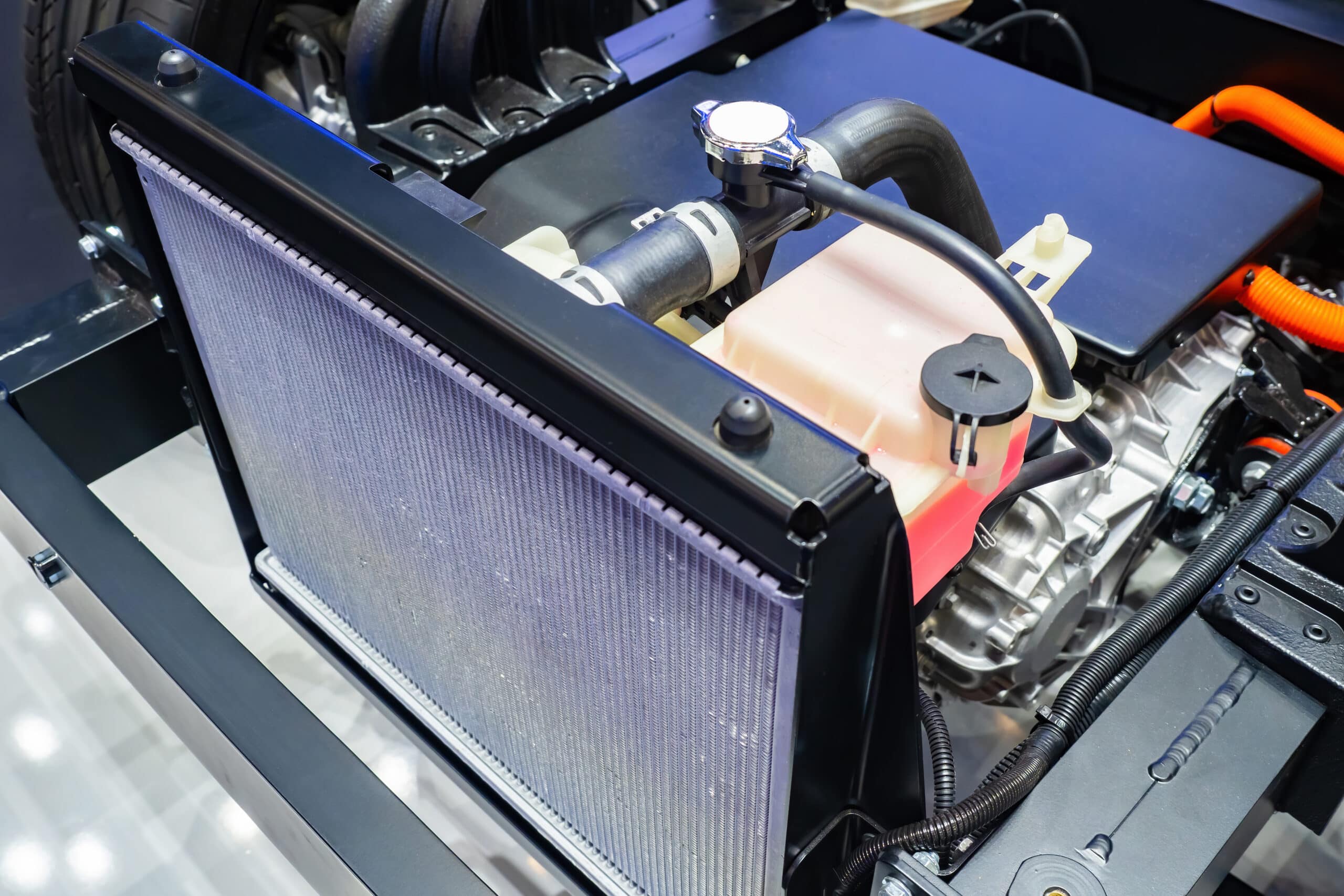 Radiator, coolant reservoir, and hoses in a vehicle engine compartment
