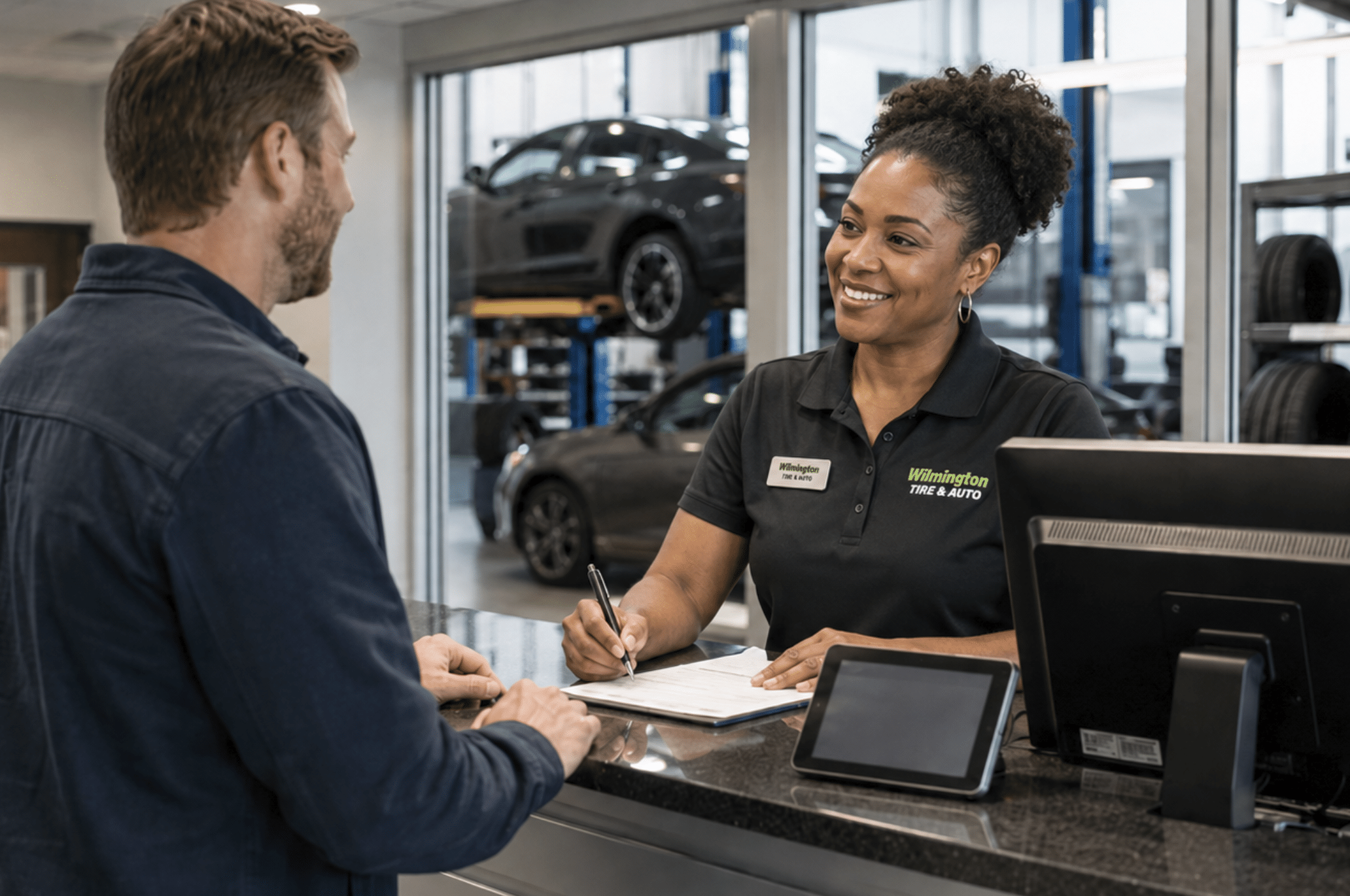 Service advisor reviewing paperwork with a customer at the counter